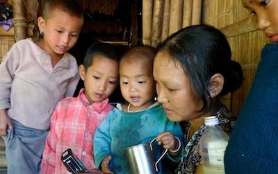 An Indian woman and her children from KajÃµ, a village in the East Kameng District, Arunachal Pradesh, India, listen to a recording of a song in Koro. The Tibeto-Burman language is considered endangered.