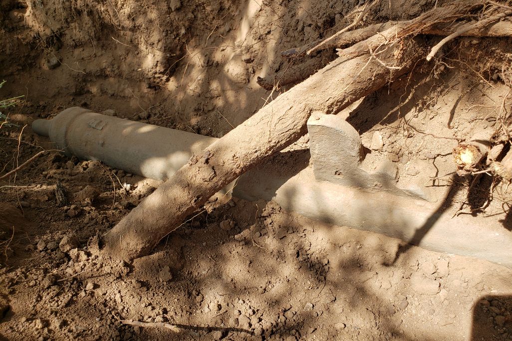 Old artifact covered in dirt on the ground