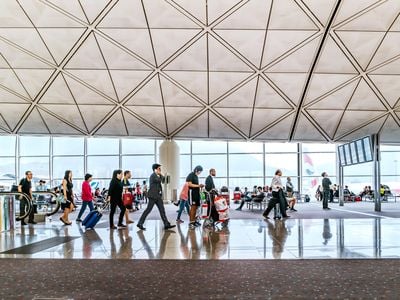 Travelers walk in the departure hall of Hong Kong International Airport.