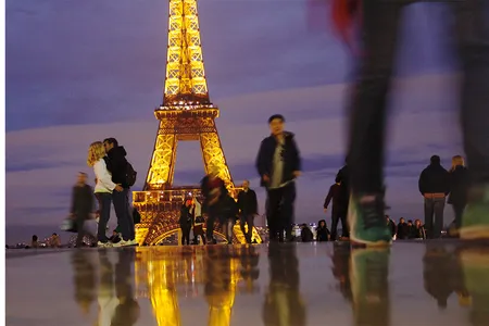 A couple kisses near the Eiffel Tower.