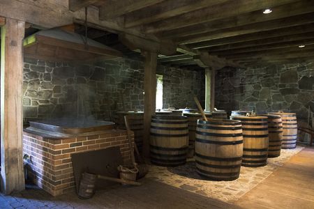 The mash floor of George Washington's Distillery. The 210 gallon boiler, left, heats water to 212 degrees so it can be used to make mash in the barrels on the right.