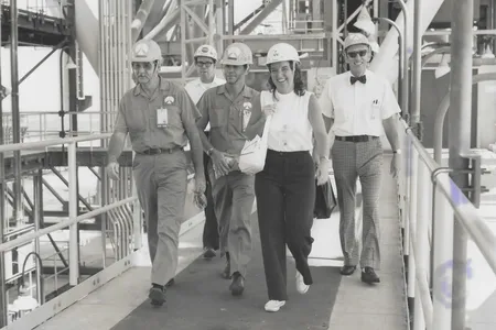 Ann Montgomery, lead crew systems engineer during the Apollo program, on the swing arm of the launch pad at Kennedy Space Center with other NASA employees, circa 1970.