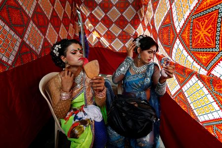 Eunuchs apply make-up before Raksha Bandhan festival celebrations in a red light area in Mumbai, India, August 17, 2016