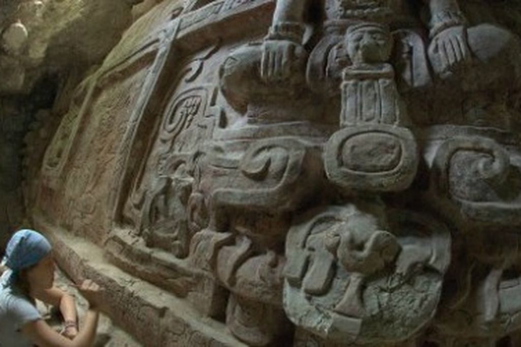 An archeologist clearing debris away from an inscription on the newly discovered frieze.