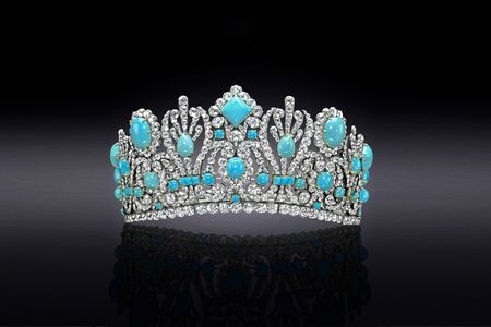 Turquoise and diamond encrusted diadem on a black background that lightens to gray in the center.