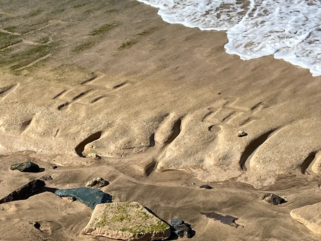 Waves approaching petroglyph on beach