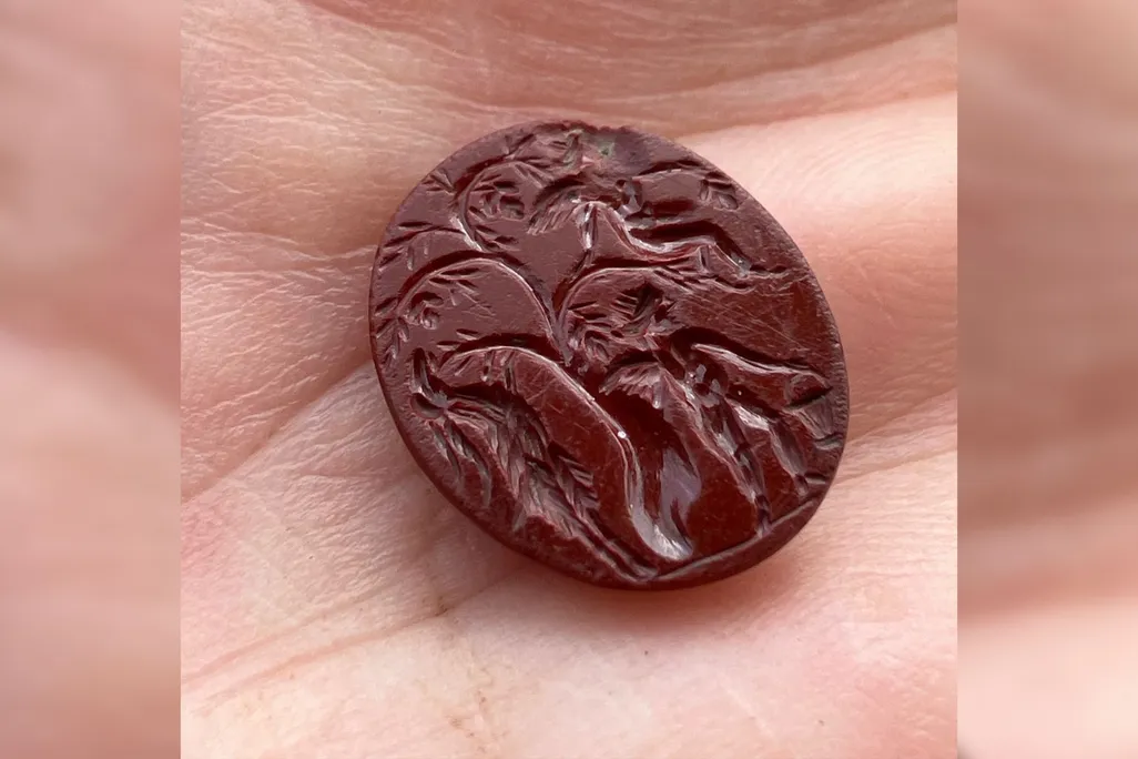 Engraved red stone in a person's hand