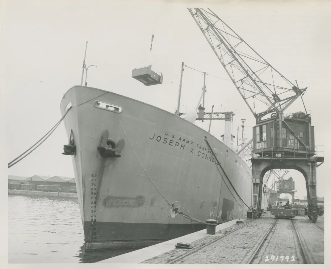 A crane lifts encased caskets into the hold of the Joseph V. Connolly at a pier in Antwerp, Belgium.