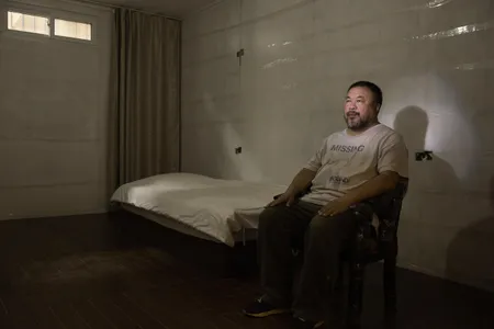 Ai sits in a replica of the prison cell in which he was detained in 2011. No one in China, he has said, "has a solid belief or trust in society."