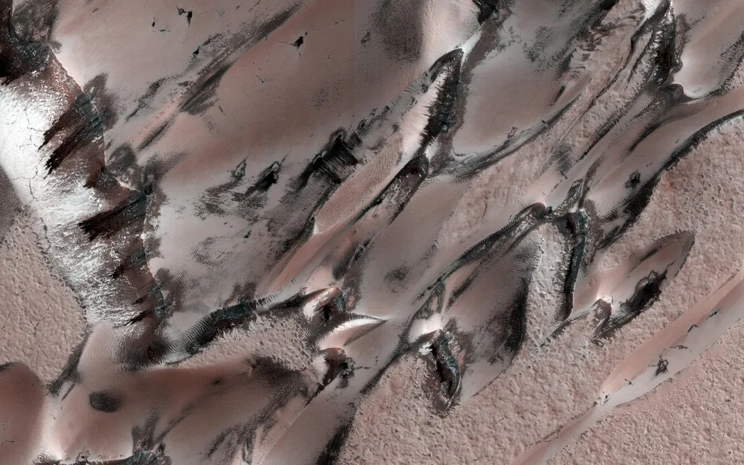 aerial shot of dark spots on dunes