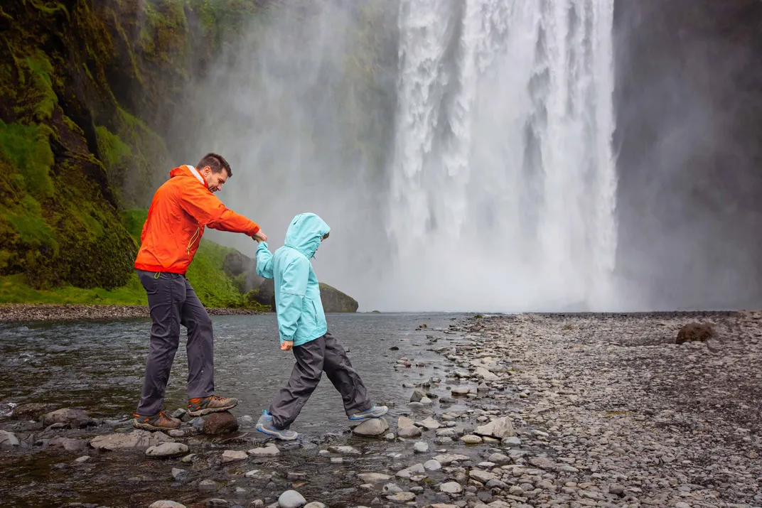 Father and son exploring a waterfall