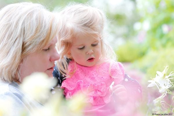 Granddaughter with Grandmother looking at Columbine flowers thumbnail