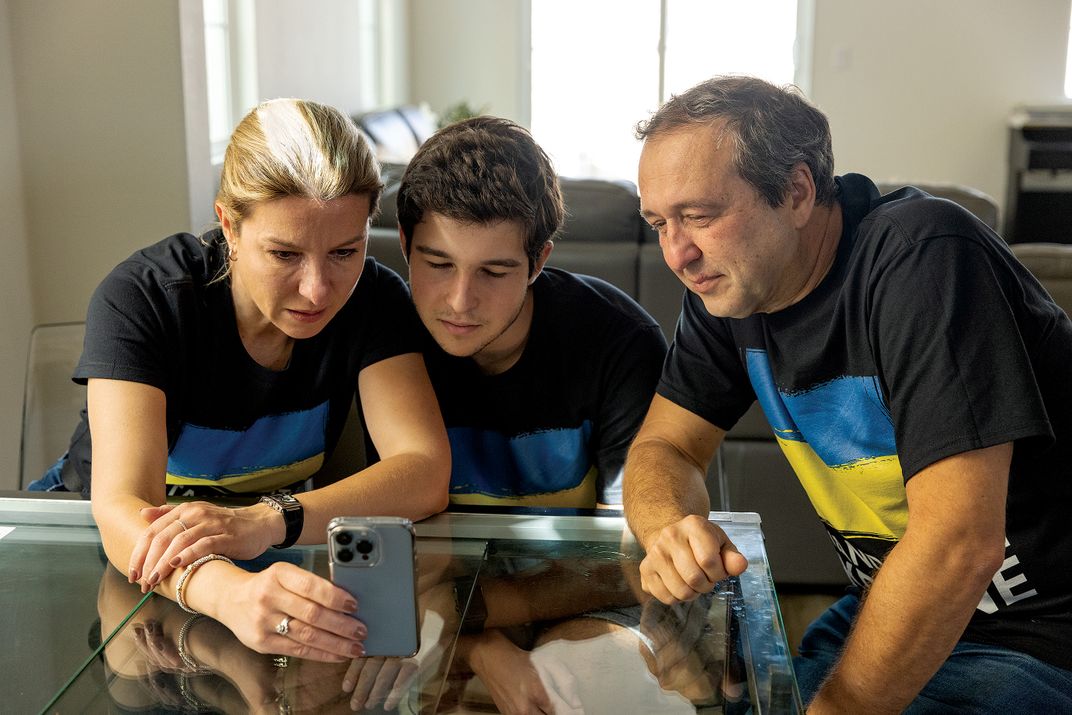 a family sits for a portrait while talking on the phone