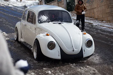 Teenagers in the West Bank hit a Volkswagen Beetle with a snowball.