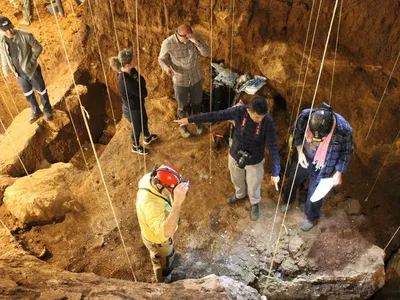 Researchers take sediment samples in the excacation pit in the&nbsp;Tam P&agrave; Ling cave in Laos, where two newly uncovered human bones&mdash;part of a skull and a shin bone&mdash;were found.