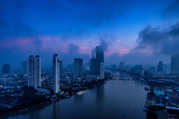 A view of the Chao Praya River and the Saphan Taksin Bridge at dawn in Bangkok. thumbnail