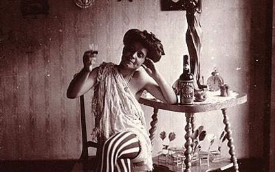 Storyville. Seated woman wearing striped stockings, drinking "Raleigh" Rye.