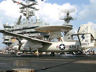 A E-2C Hawkeye on the flight deck of the USS Harry S. Truman, circa 2005. Each ship has a sponsor—a living woman, normally a civilian—who is considered a permanent member of the ship&#39;s crew, and is considered to bestow a part of her personality to the ship.