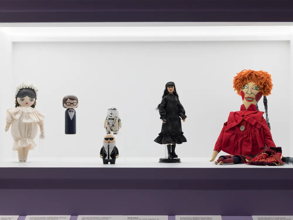 A display case featuring "Dolls as Designers," including Yves Saint Laurent (second from left) and Anna Sui (second from right)