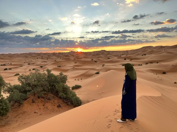 Berber man watching the sun rise over the Moroccan Sahara thumbnail