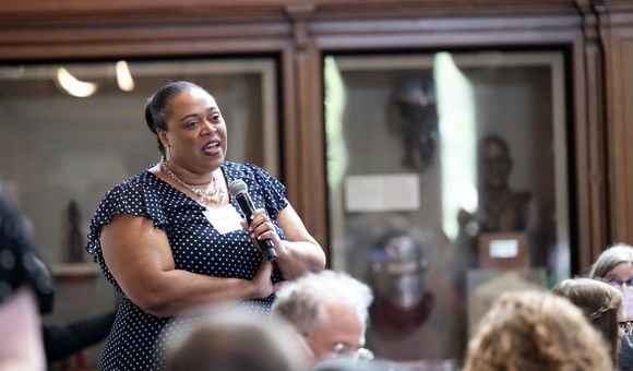 Woman with crossed arms holds a microphone