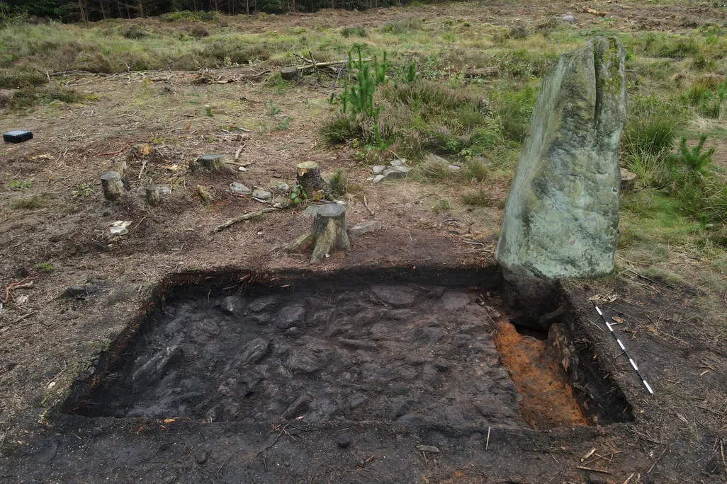 Large stone next to excavated rectangle area