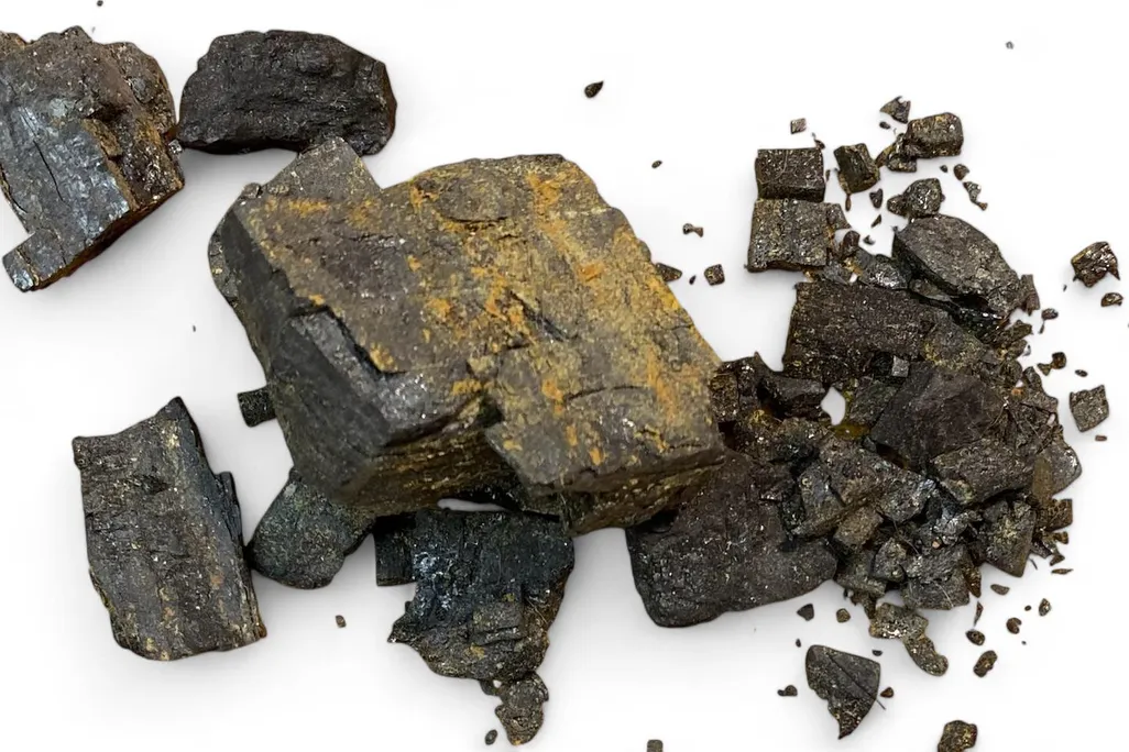 Broken pieces of coal against a white background