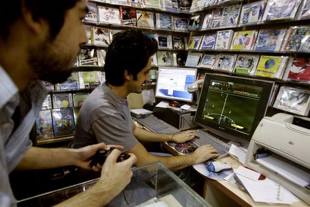 Iranian men play a soccer video game at a CD shop in Tehran June 10, 2006.