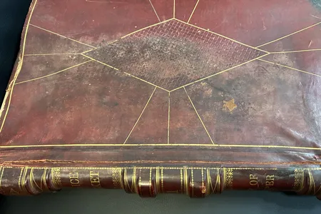 The 315-page police docket from 1904 is bound in red leather with gold accents.