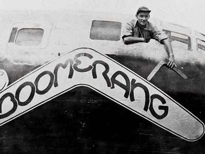 Carl Schahrer, commander of the B-29 Boomerang, shows off the talisman, on which his crew carved their missions.