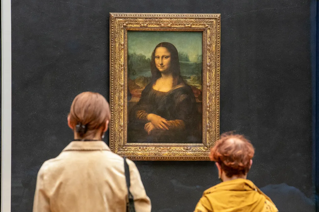 Backs of two peoples' heads as they look at the Mona Lisa