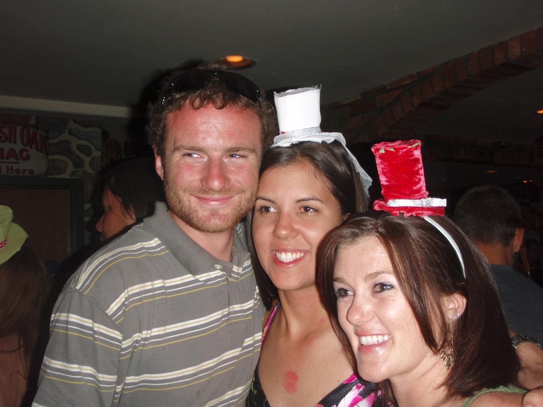 One guy and two women smiling while posing for a photo