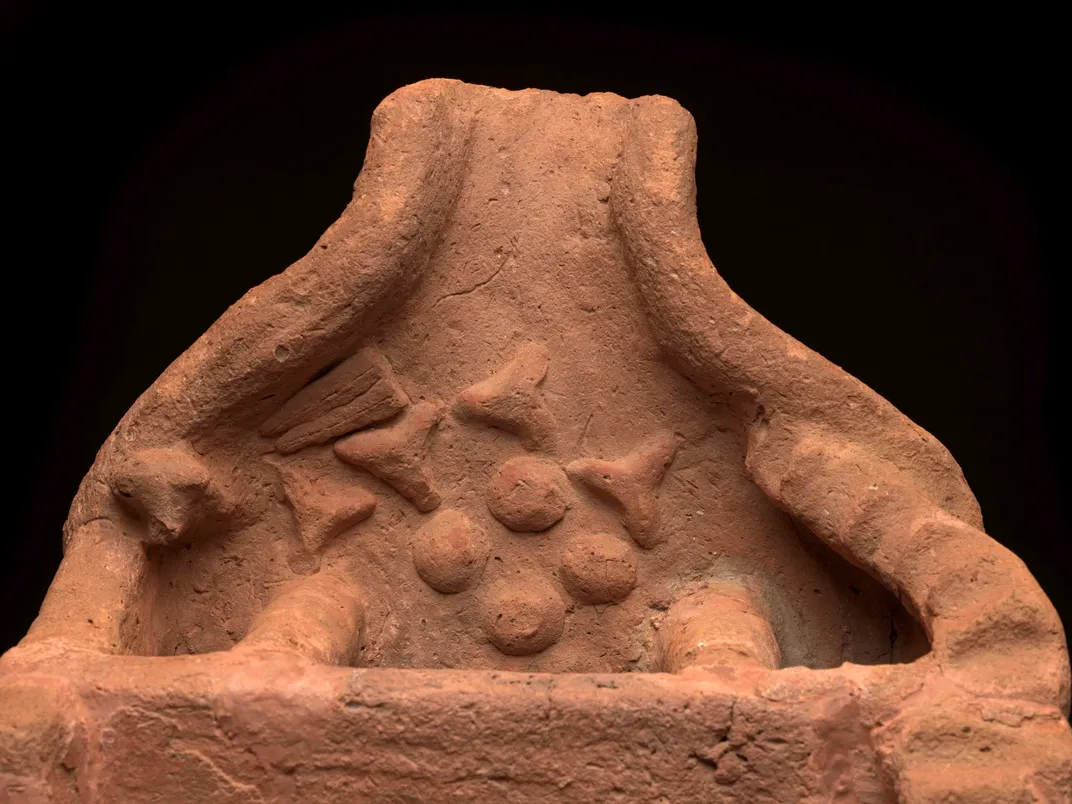 The open space at the front of the "soul house" has various offerings, including triangular loaves of bread, a lettuce and an ox’s head.