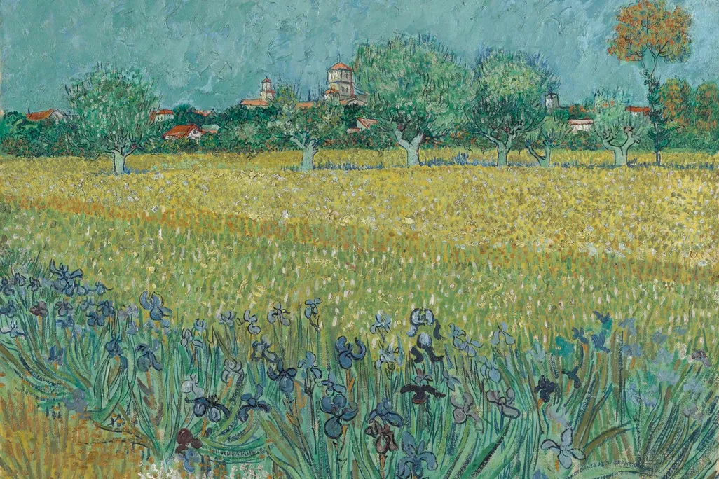 A painting of deep blue irises and a yellowish field, with a muted blue sky and trees behind