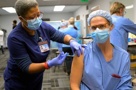 An RN administers the Covid-19 vaccine to a nurse at the Virginia Hospital Center in Arlington, Virginia.  