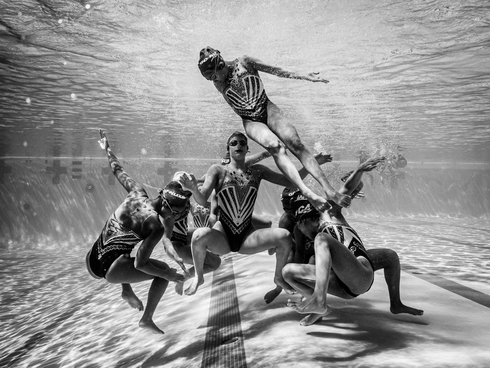 A synchronized swimmer returns underwater after being lifted by her