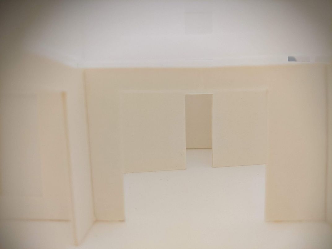 Diorama-like structure that looks like a small apartment with blank white walls.