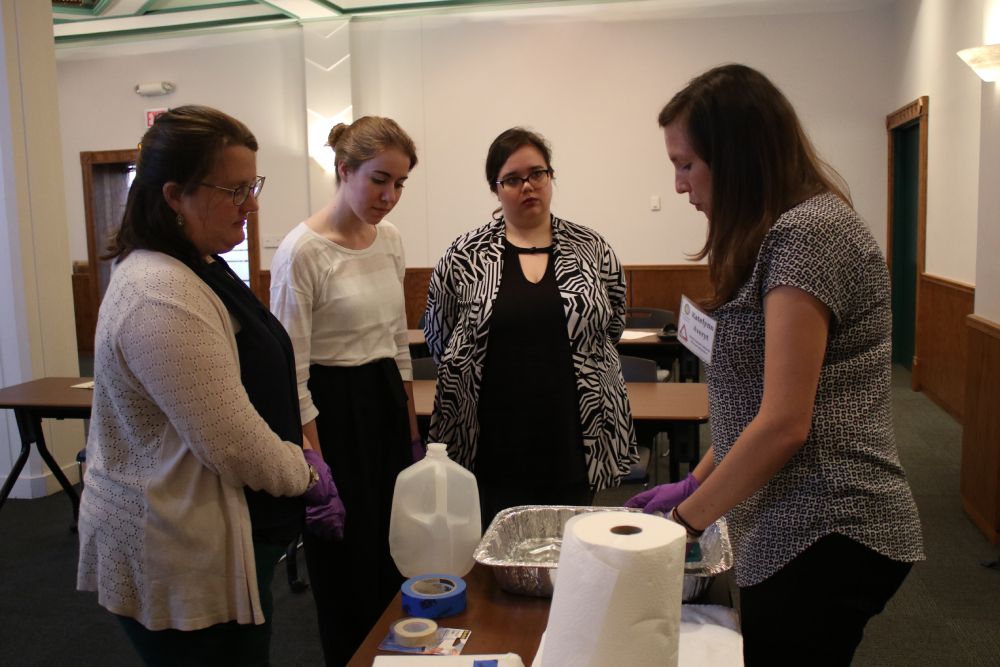 Four women talk around a table.