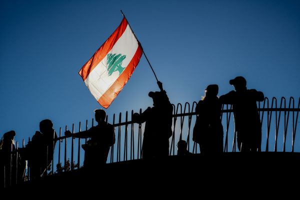 A demonstrator waves the flag of Lebanon during a Free Palestine Protest thumbnail