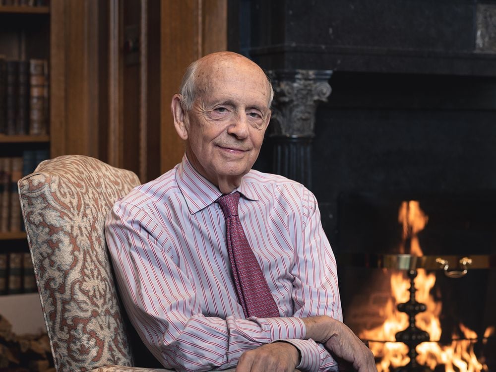 The cover of the book, Reading the Constitution, features Justice Stephen Breyer sitting in front of a blazing fire.