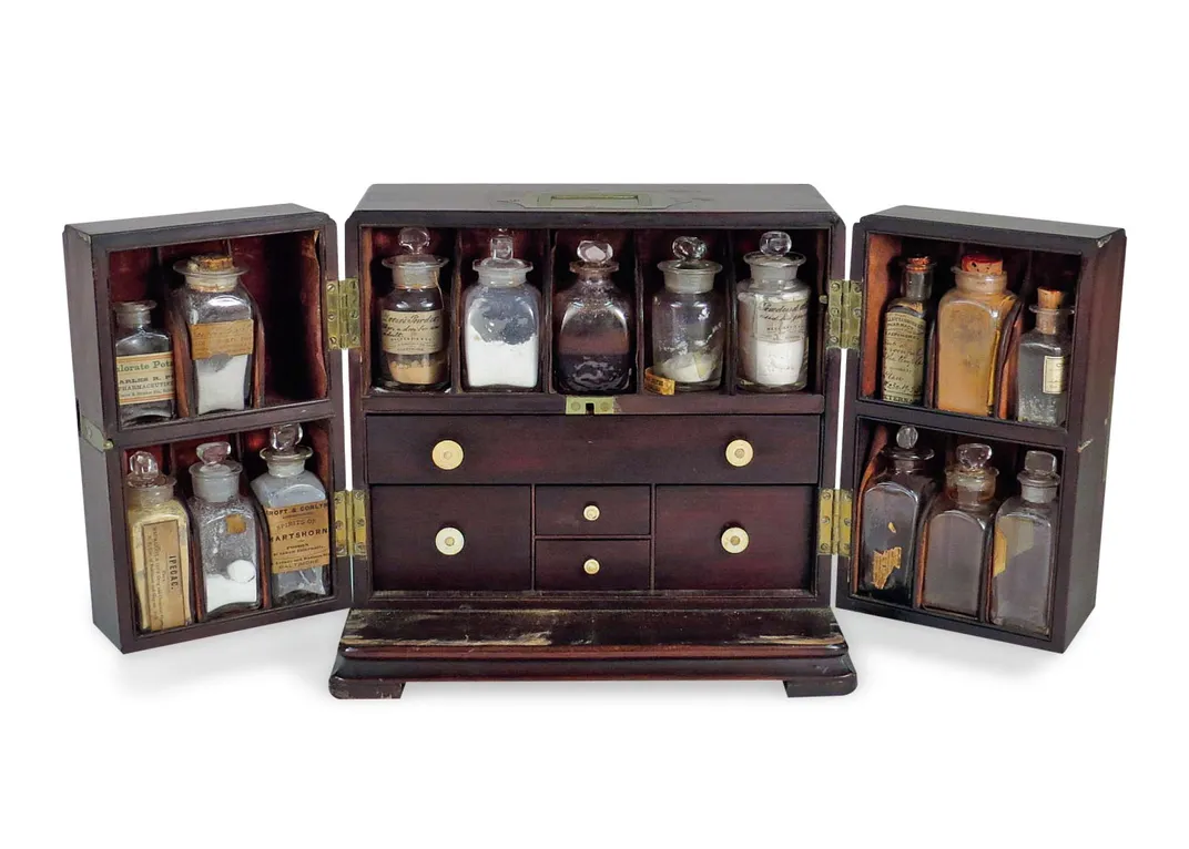 a wooden medical cabinet holding glass medicine bottles