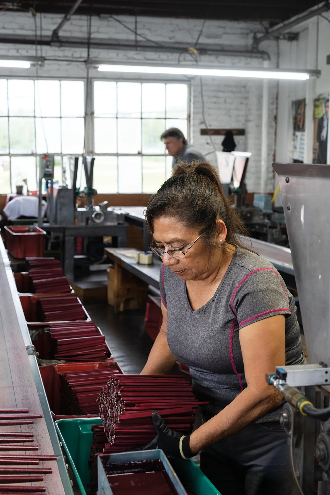 a woman works in a pencil factory