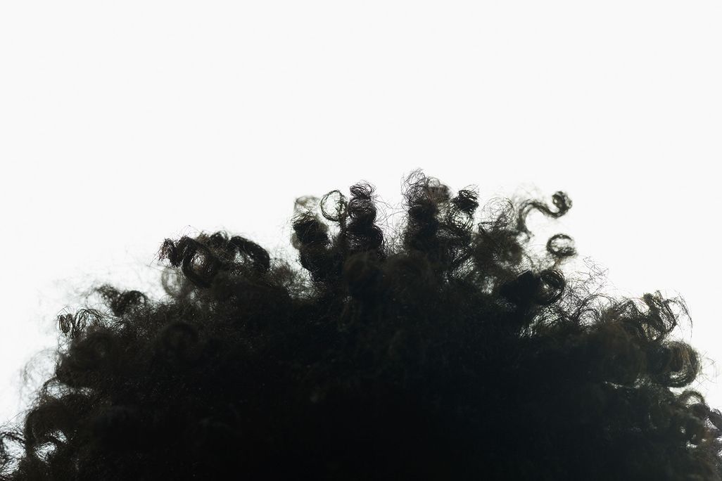 top of a head covered in black curly hair