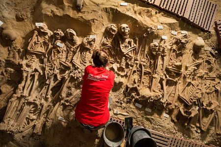 An archeologist from Inrap excavates a mass grave below a supermarket in Paris