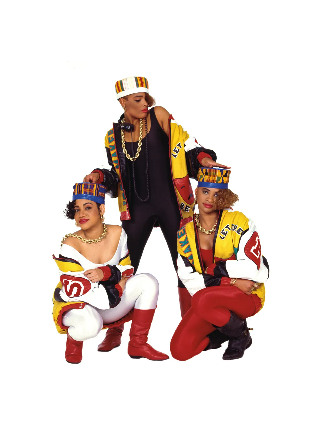 three Black women in matching outfits pose for a group portrait