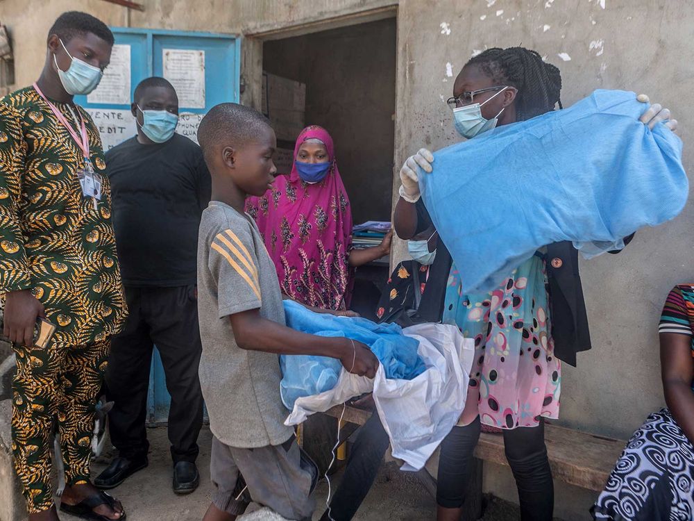 Handing out bed nets in West Africa