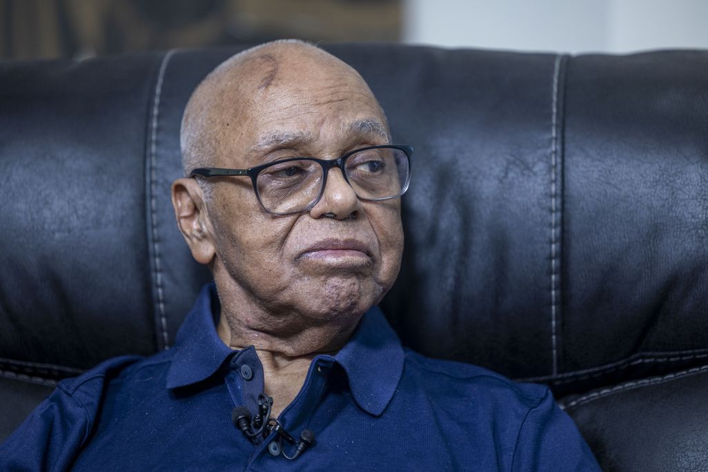 Black man sitting up and looking to the right