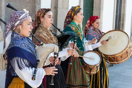 Via Getty: "A group of young women in traditional costumes play Galician music with bagpipes, tambourines and drum in the historic center during the San Froilan festivities on October 6, 2019 in Lugo, Galicia, Spain." 