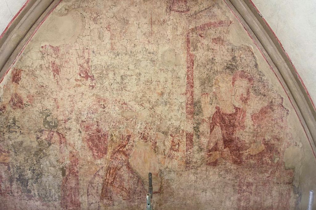 A very faded red and taupe frescoe with the outlines of some figures visible, enclosed in an arched dome