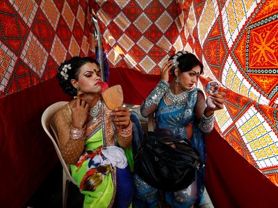Eunuchs apply make-up before Raksha Bandhan festival celebrations in a red light area in Mumbai, India, August 17, 2016